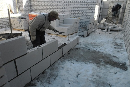 Укладка блоков строителем